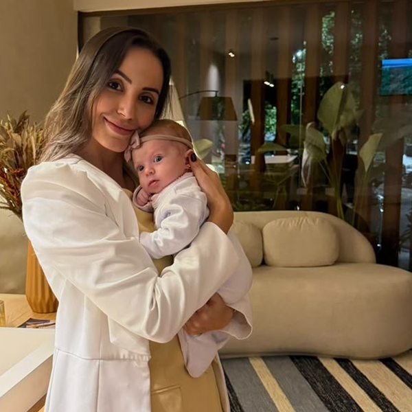 Dra. Amanda Rocha com uma bebê no colo, sorrindo